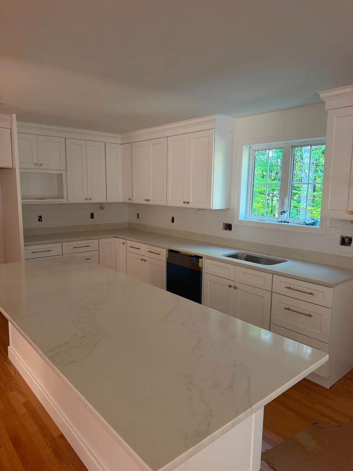 White stone kitchen island and perimeter countertops in a bright kitchen